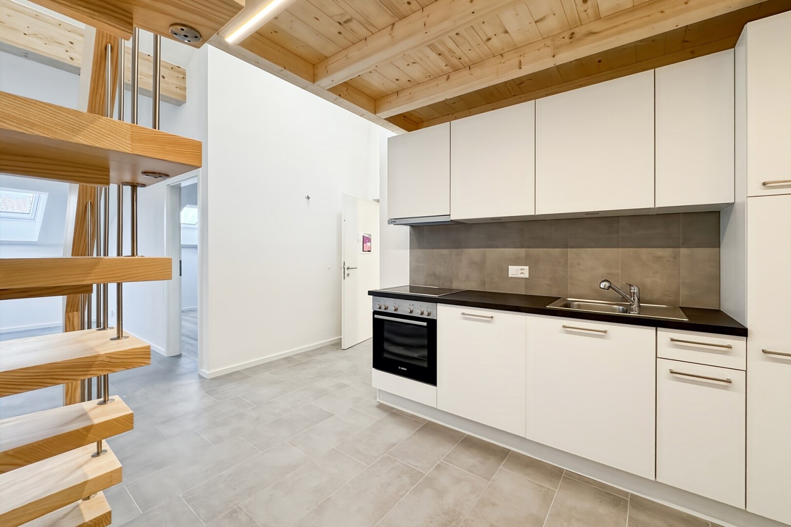 cuisine avec dark countertops, plans de travail, white cabinets, armoires blanches, et light floor