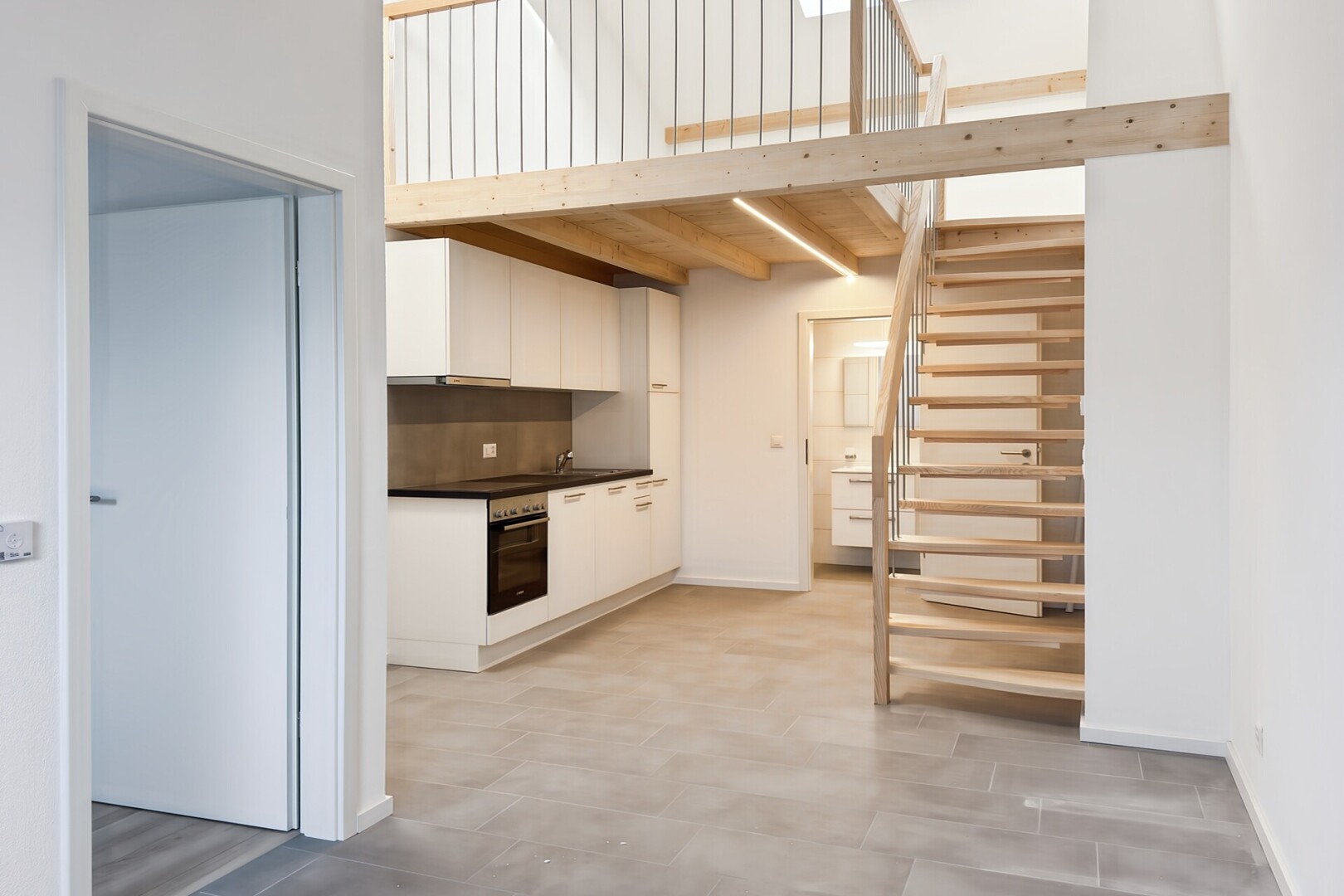 cuisine avec cloison sèche, drywall, plans de travail, dark countertops, et armoires blanches