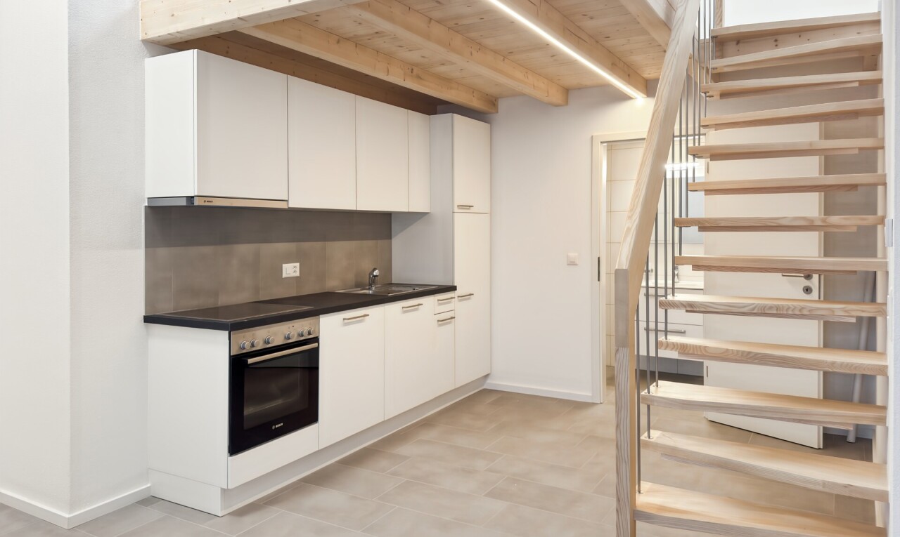 cuisine avec plans de travail, dark countertops, light floor, four, et cloison sèche