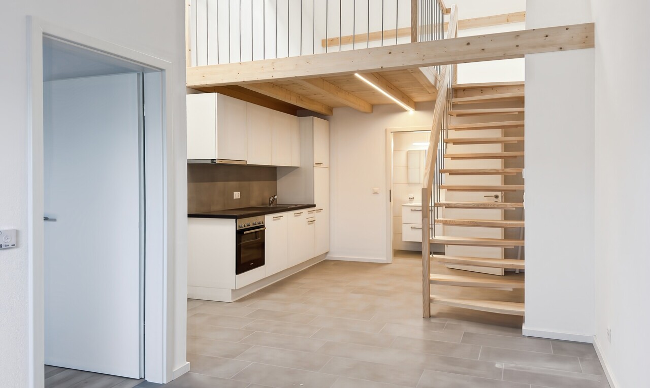 cuisine avec cloison sèche, drywall, plans de travail, dark countertops, et armoires blanches