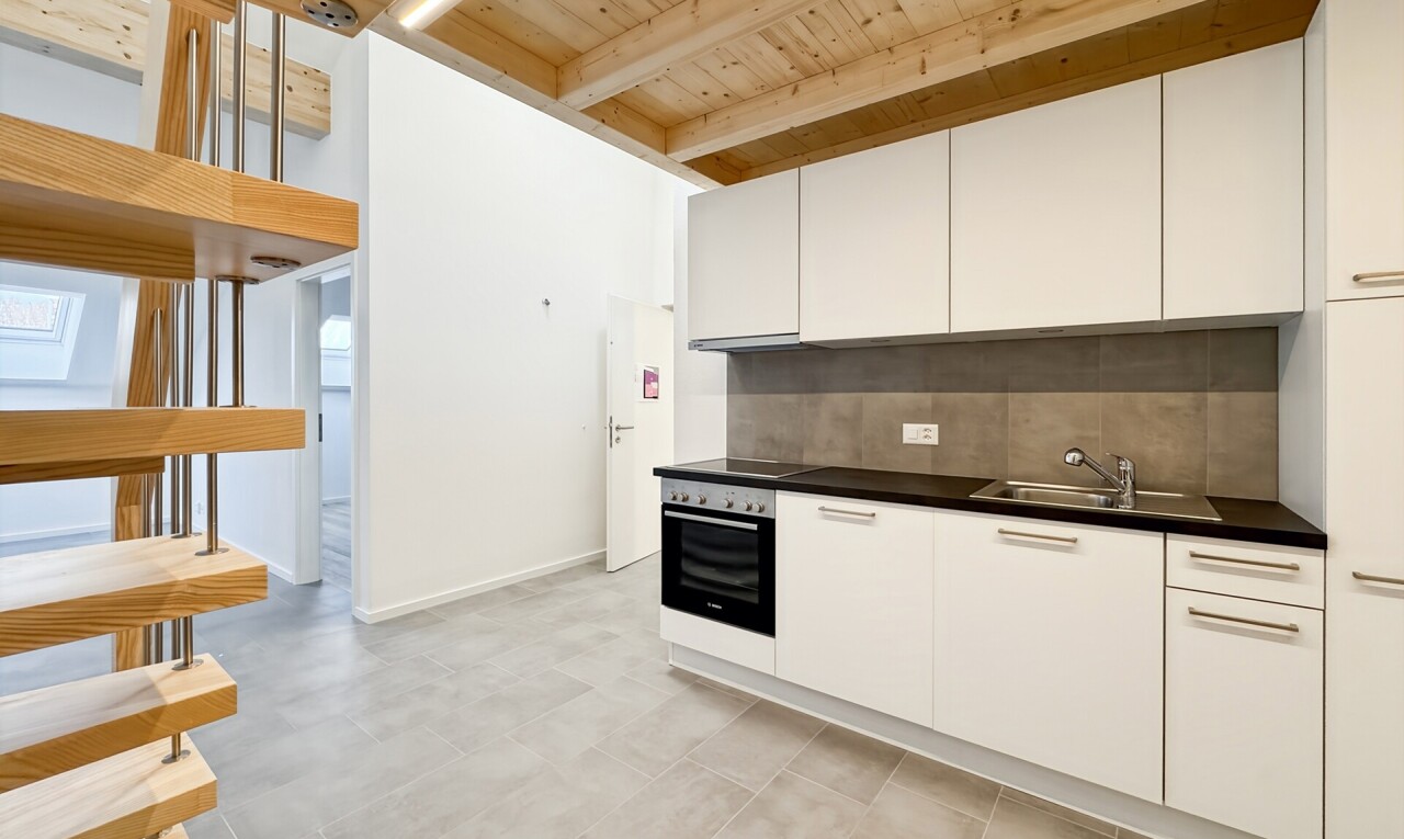 cuisine avec dark countertops, plans de travail, white cabinets, armoires blanches, et light floor