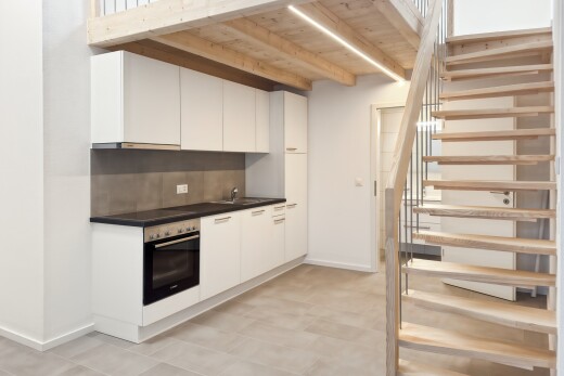 cuisine avec plans de travail, dark countertops, light floor, four, et cloison sèche