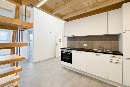 cuisine avec dark countertops, plans de travail, white cabinets, armoires blanches, et light floor