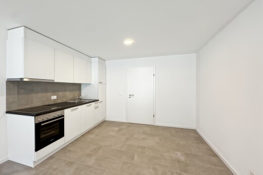 cuisine avec dark countertops, plans de travail, four, light floor, et drywall
