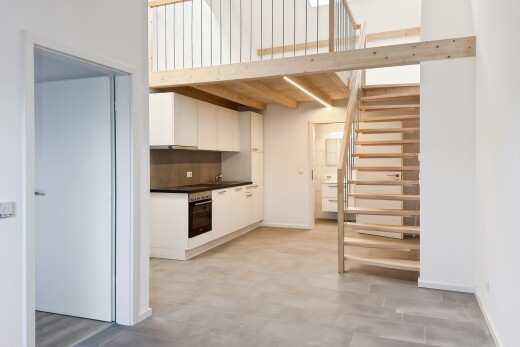 cuisine avec cloison sèche, drywall, plans de travail, dark countertops, et armoires blanches