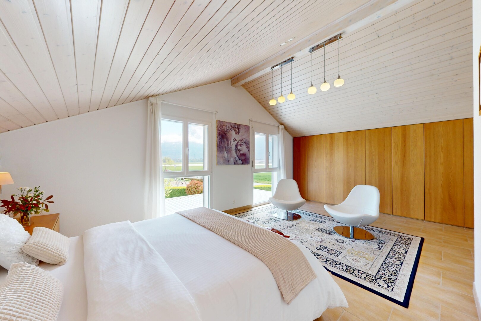 chambre avec plafond voûté, plafond en bois, sol en finition bois, lumière naturelle, et cloison sèche