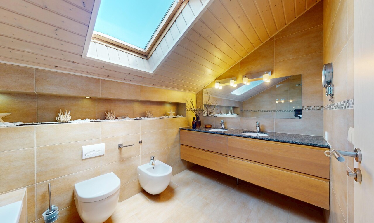 salle de bains avec mur en carrelage, plafond voûté, et évier
