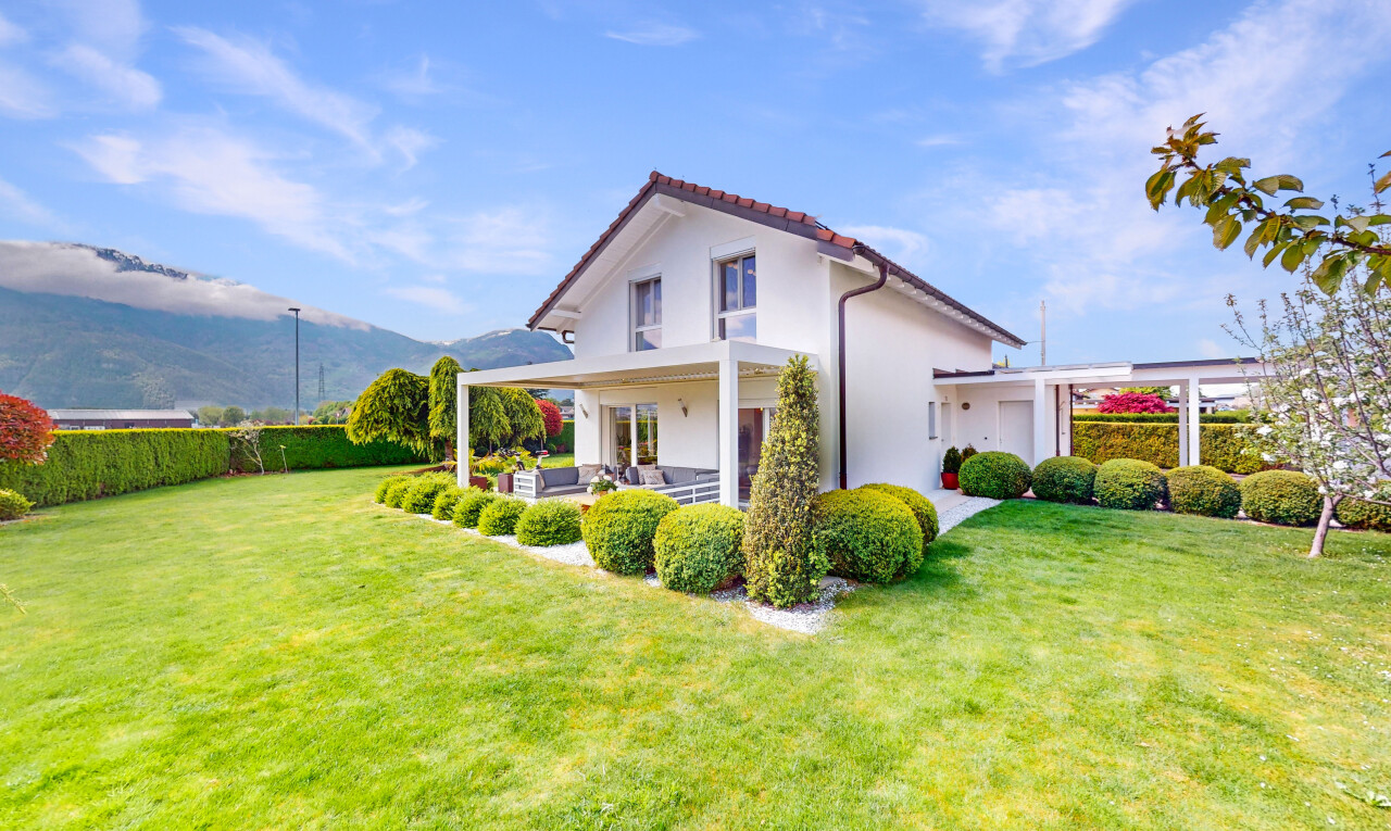 façade avec espace de vie extérieur, bardage en stuc, et pelouse