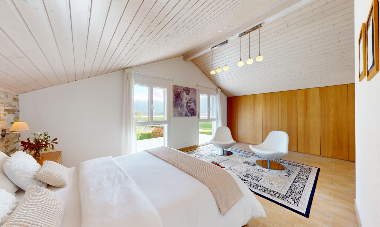 chambre avec plafond voûté, plafond en bois, sol en finition bois, lumière naturelle, et cloison sèche