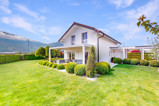 façade avec espace de vie extérieur, bardage en stuc, et pelouse