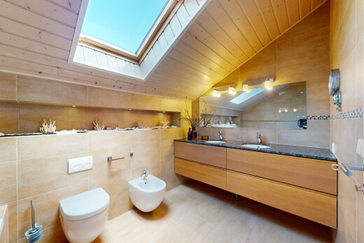 salle de bains avec mur en carrelage, plafond voûté, et évier