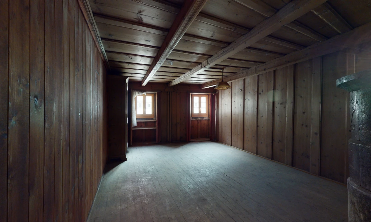 chambre vide avec parquet, lumière naturelle, et poutres apparentes
