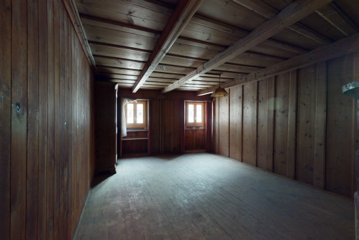 chambre vide avec parquet, lumière naturelle, et poutres apparentes