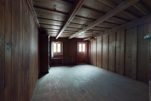 chambre vide avec parquet, lumière naturelle, et poutres apparentes