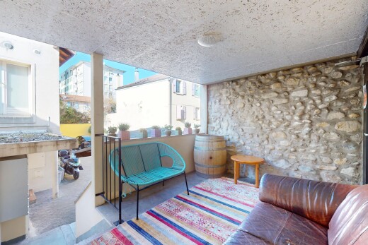 salon avec lumière naturelle, mur en pierre, et plafond en crépis