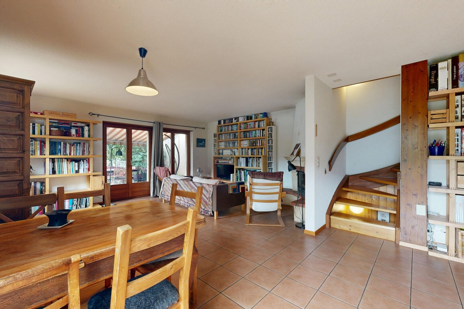 salle à manger avec étagères intégrées, escaliers, sol en carrelage, tile floor, et éclairage suspendu