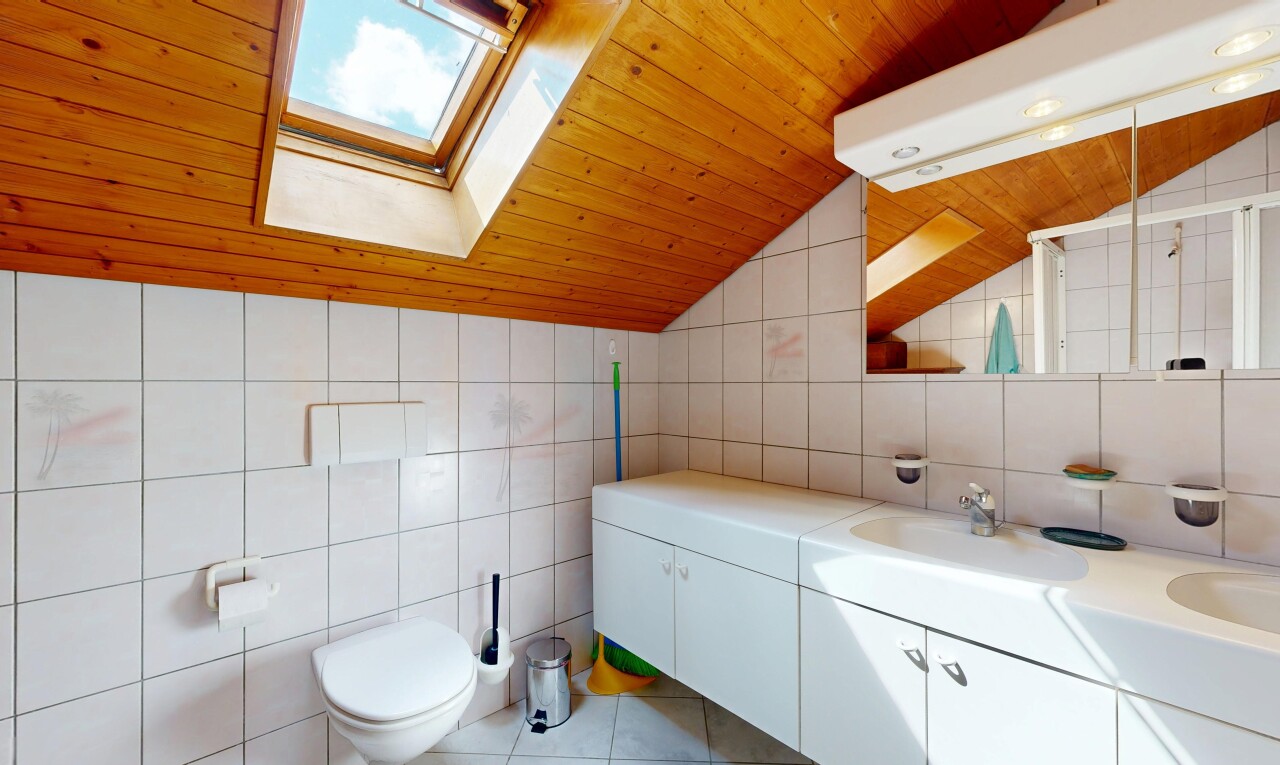 salle de bains avec mur en carrelage, tile wall, lavabo (ou coiffeuse selon le contexte), plafond en bois, et wood ceiling