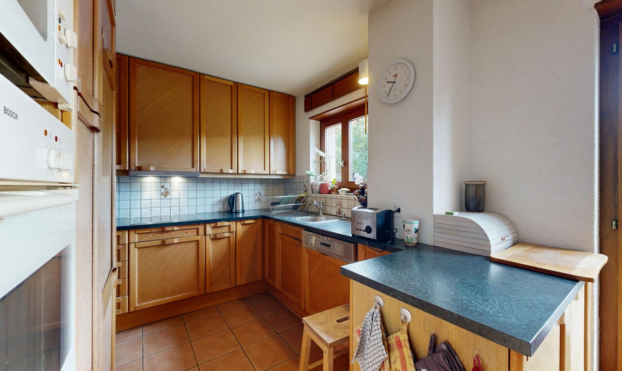 cuisine avec plans de travail, dark countertops, armoires de style shaker, shaker cabinets, et dosseret