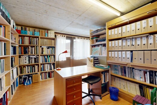 bureau avec wood finish floor, étagères intégrées, inside community, concrete ceiling, et light floor
