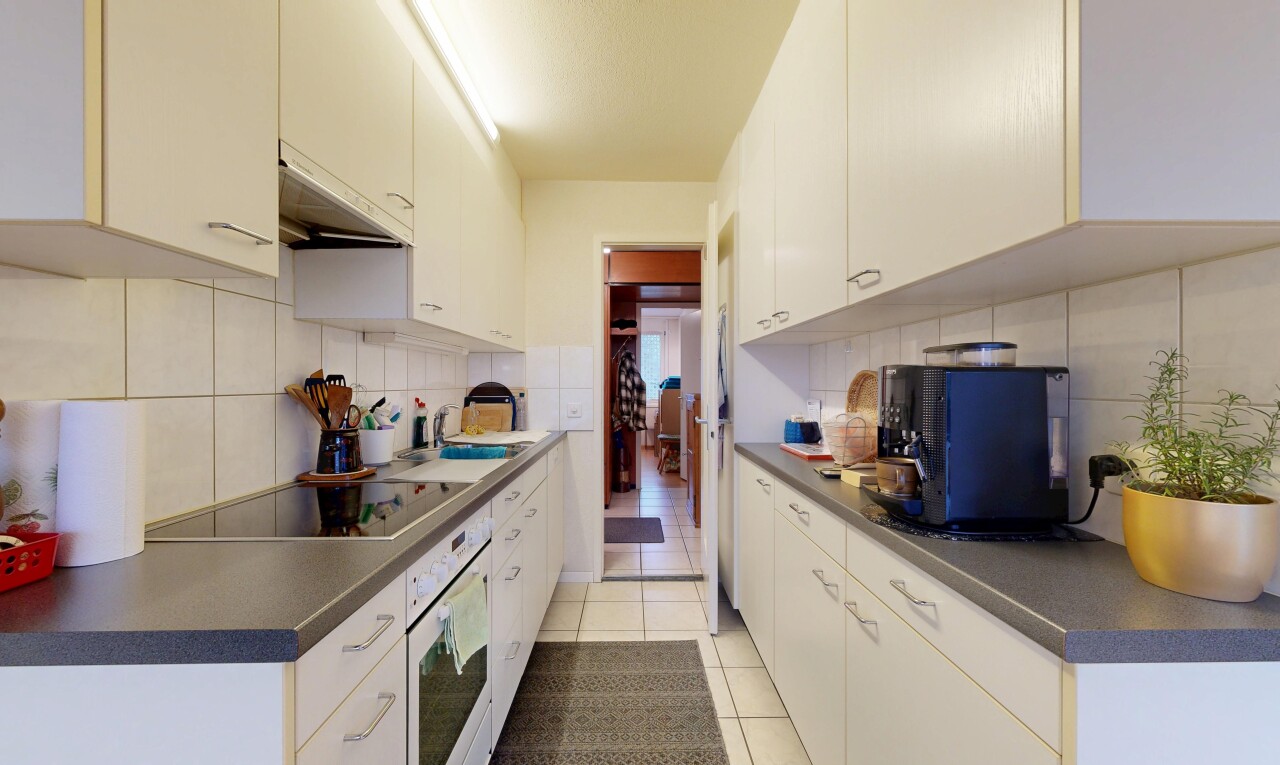 kitchen featuring dark countertops, light tile patterned floors, white oven, under cabinet range hood, and white cabinetry