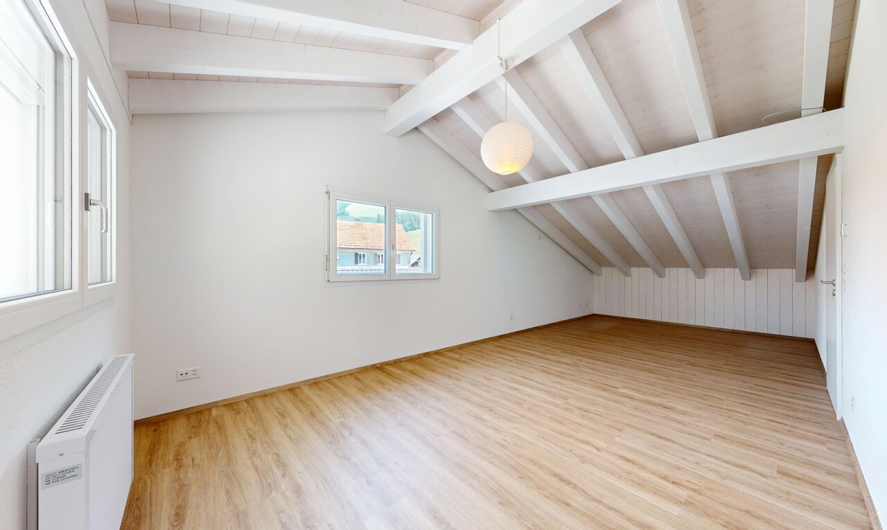 leerer raum mit vaulted ceiling, dachschräge, pendelleuchte, wood finish floor, und holzfußboden