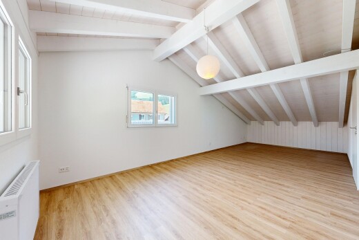 leerer raum mit vaulted ceiling, dachschräge, pendelleuchte, wood finish floor, und holzfußboden