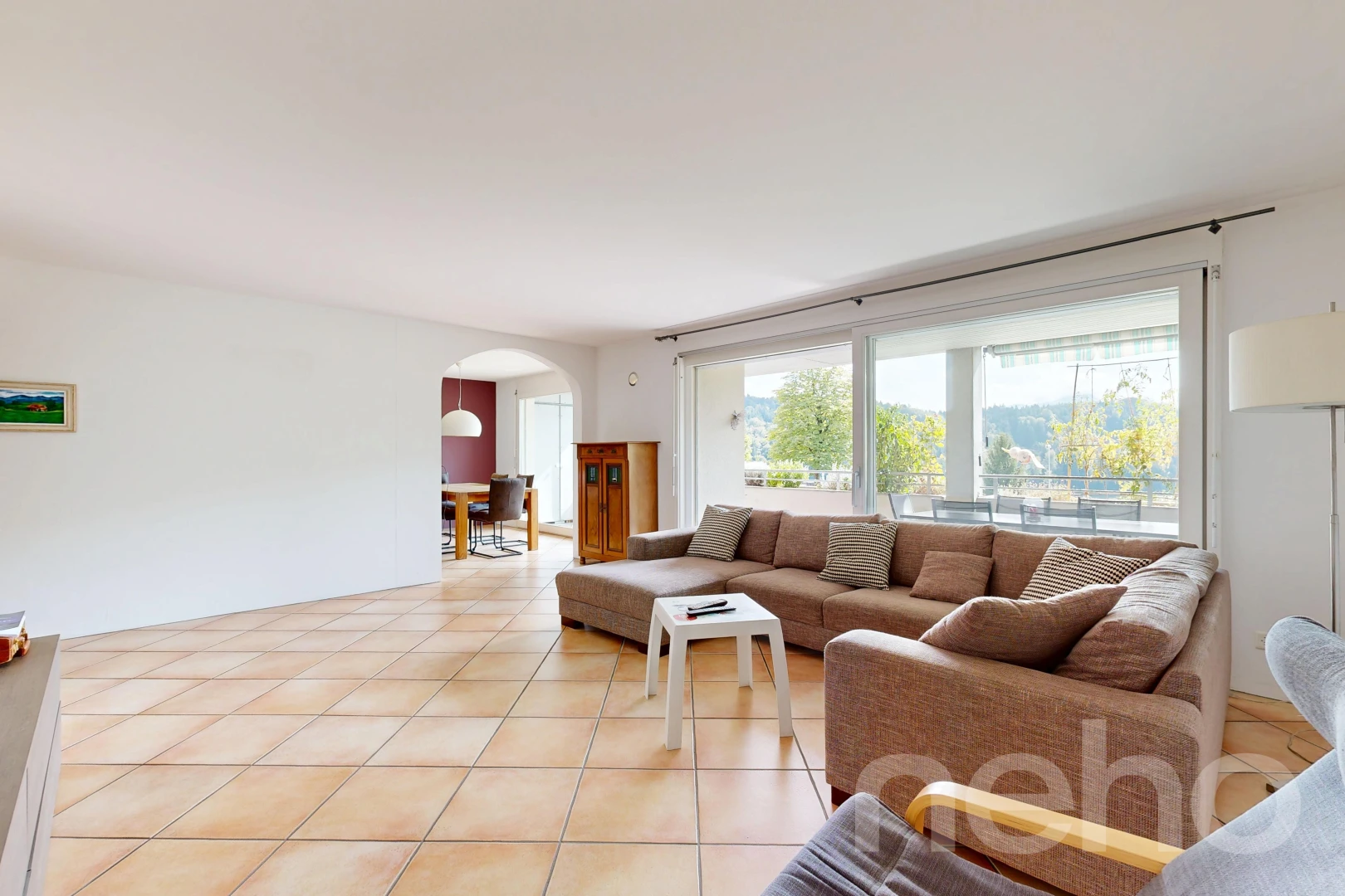 living room featuring arched walkways and light tile patterned floors