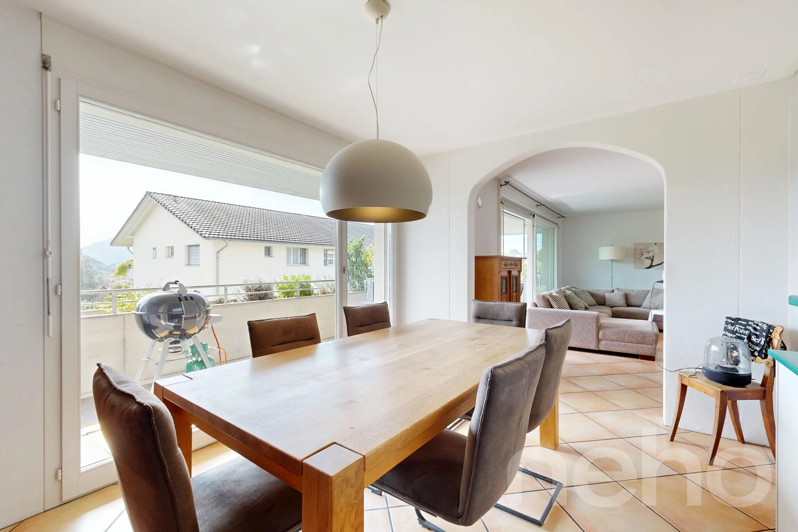 living / dining room with pendant lighting, arched walkways, access to exterior, and light tile patterned flooring