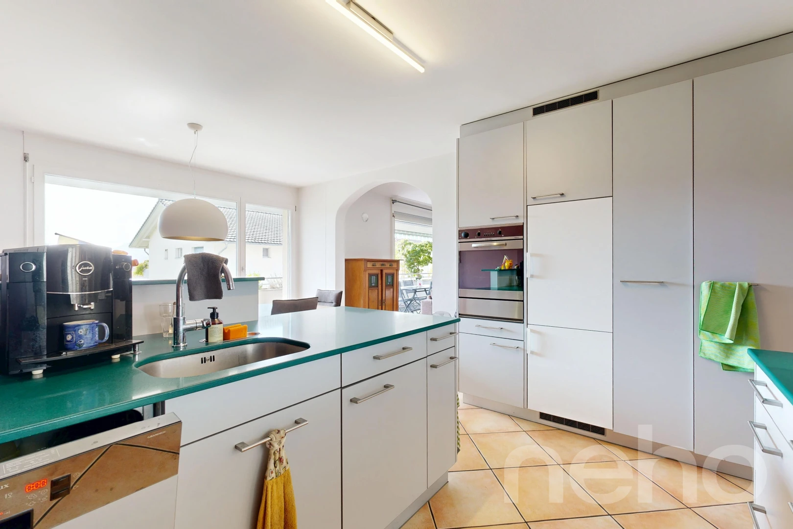kitchen with arched walkways, pendant lighting, dishwashing machine, light tile patterned flooring, and oven