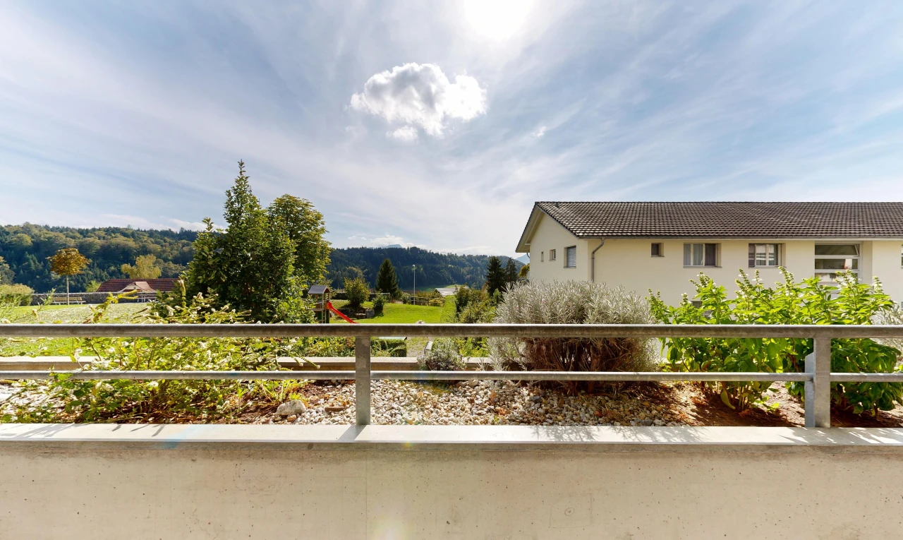 view of property with a balcony and a tile roof