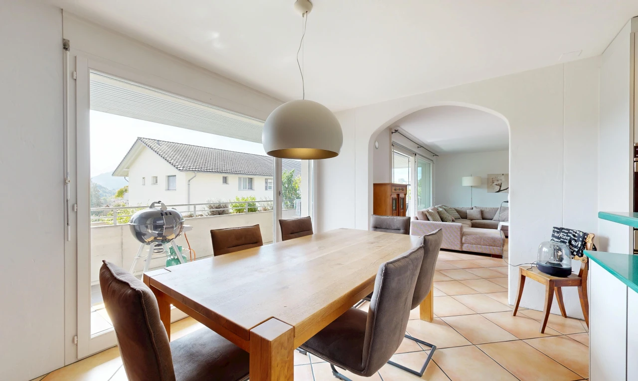 living / dining room with pendant lighting, arched walkways, access to exterior, and light tile patterned flooring