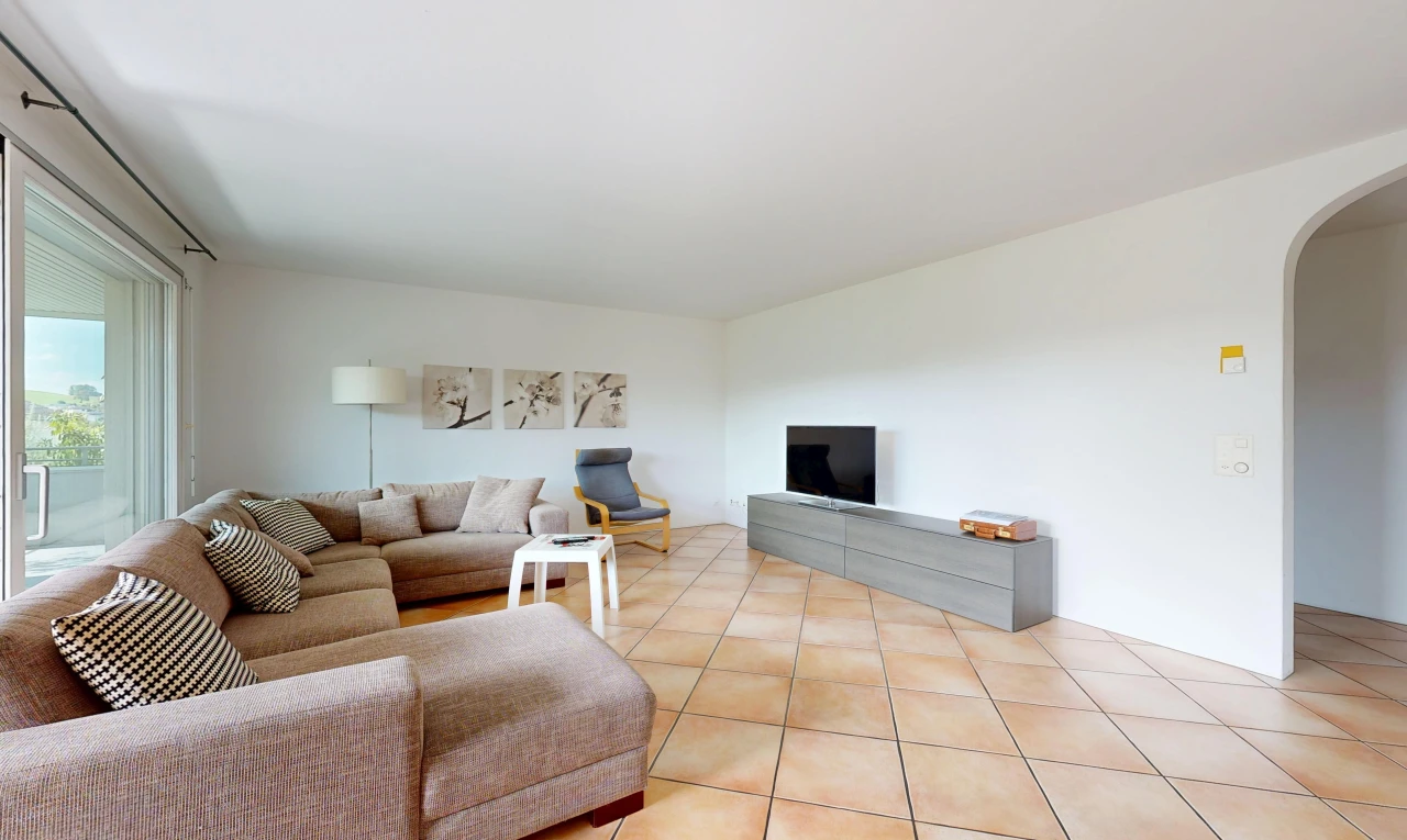 living area featuring arched walkways and light tile patterned floors