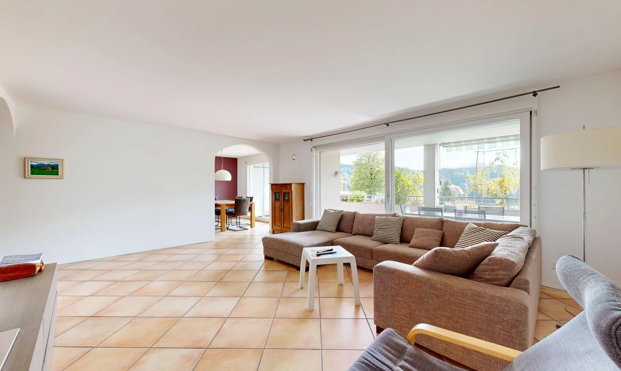 living room featuring arched walkways and light tile patterned floors