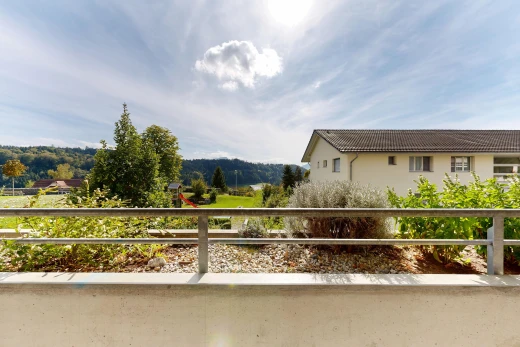 view of property with a balcony and a tile roof