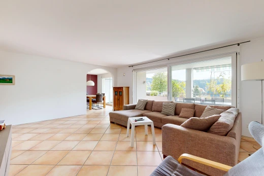 living room featuring arched walkways and light tile patterned floors