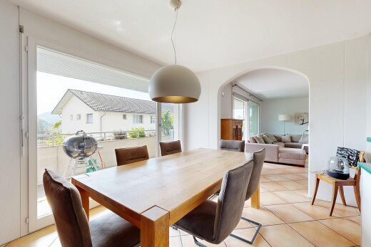 living / dining room with pendant lighting, arched walkways, access to exterior, and light tile patterned flooring