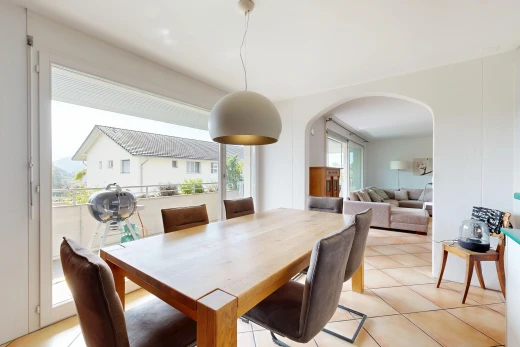 living / dining room with pendant lighting, arched walkways, access to exterior, and light tile patterned flooring