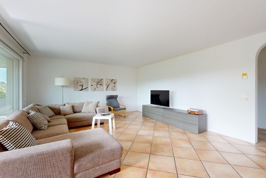 living area featuring arched walkways and light tile patterned floors