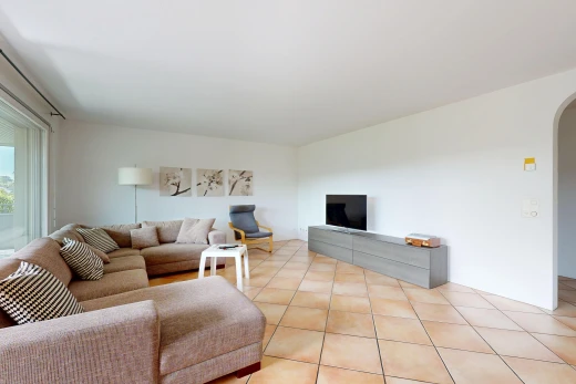 living area featuring arched walkways and light tile patterned floors