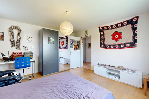 room with light wood-style floors, decorative light fixtures, and an office area