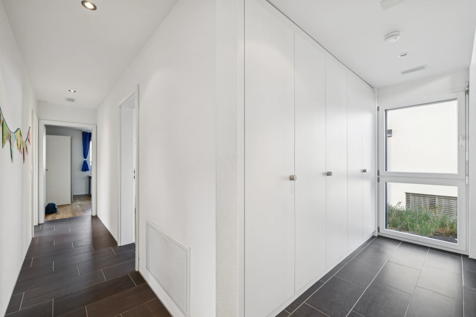 halle / korridor mit inside property, dark floor, einbauleuchten, kleiderschrank, und drywall