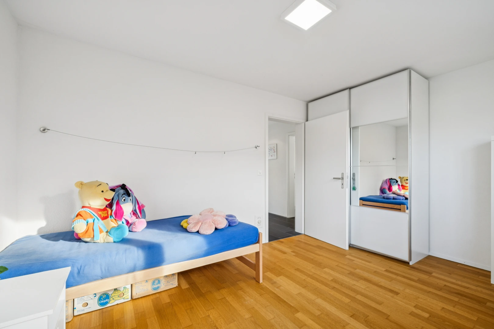 zimmer / schlafzimmer mit drywall, gipskartonwand, wood finish floor, holzfußboden, und inside property