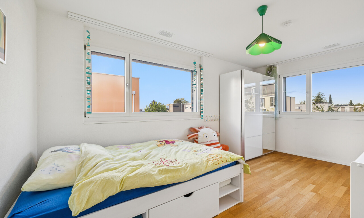 room / bedroom with pendant lighting, light wood-style flooring, and multiple windows