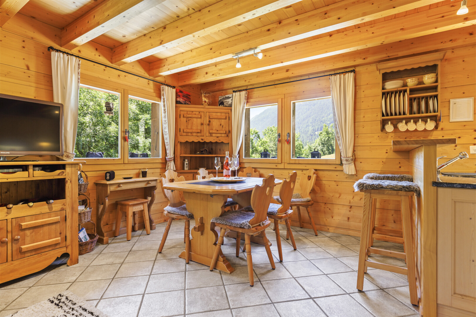 salle à manger avec sol en carrelage, tile floor, mur en bois, wood wall, et télévision