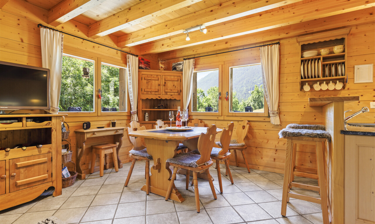 dining space with light tile patterned flooring, wood walls, and beamed ceiling