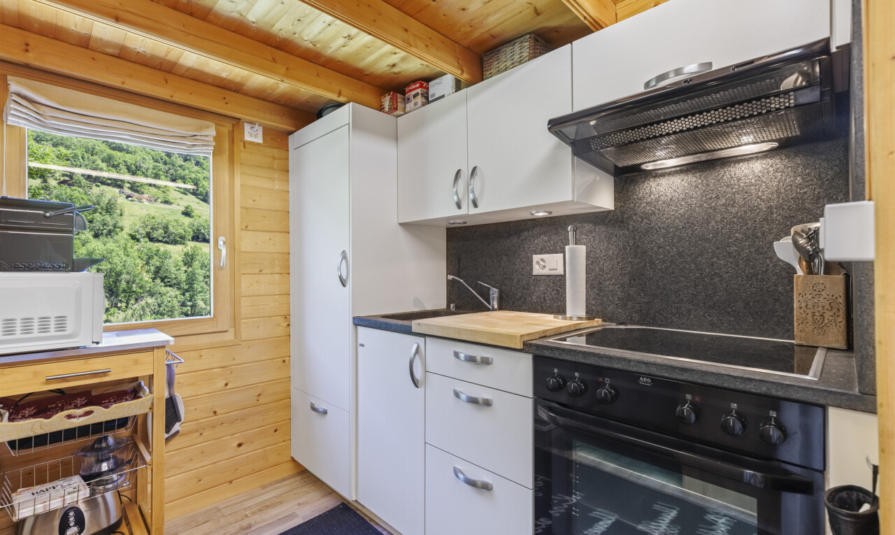 kitchen featuring black appliances, white cabinetry, wood walls, butcher block counters, and wood ceiling