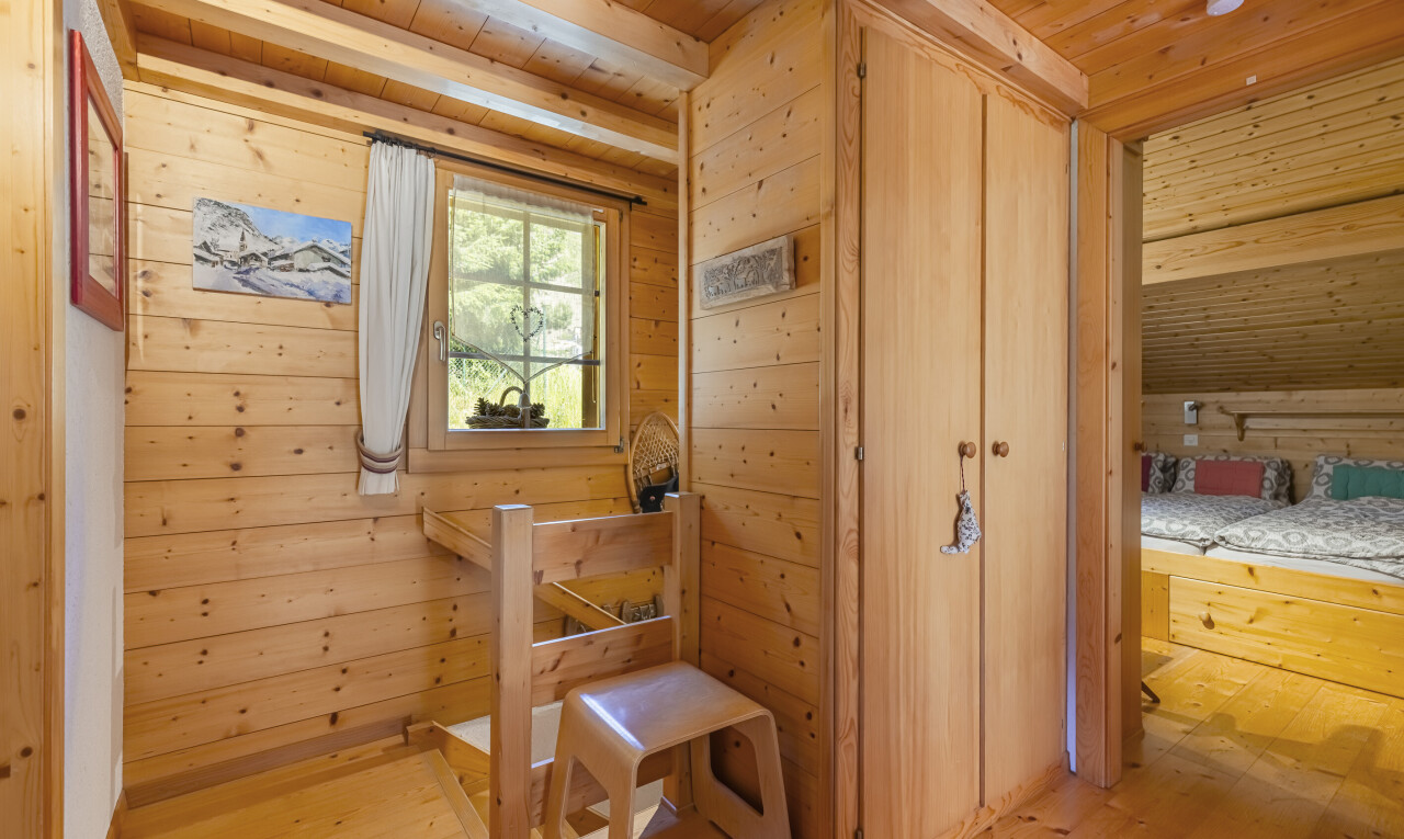 chambre avec placard, plafond en bois, wood ceiling, mur en bois, et wood wall