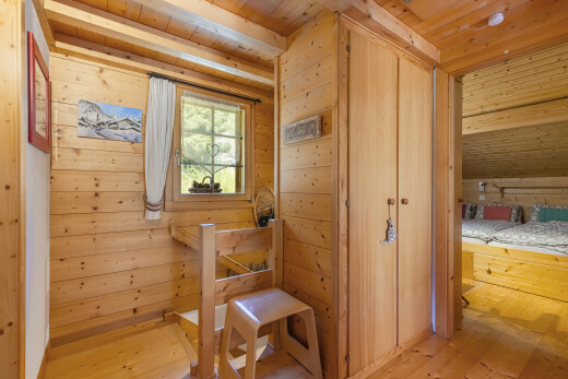 chambre avec placard, plafond en bois, wood ceiling, mur en bois, et wood wall