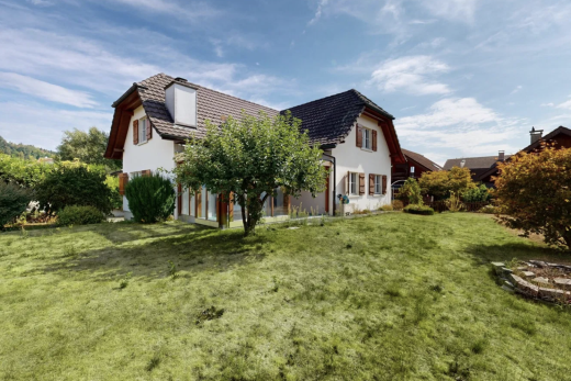 view of property featuring a lawn, a tiled roof, a chimney, and stucco siding