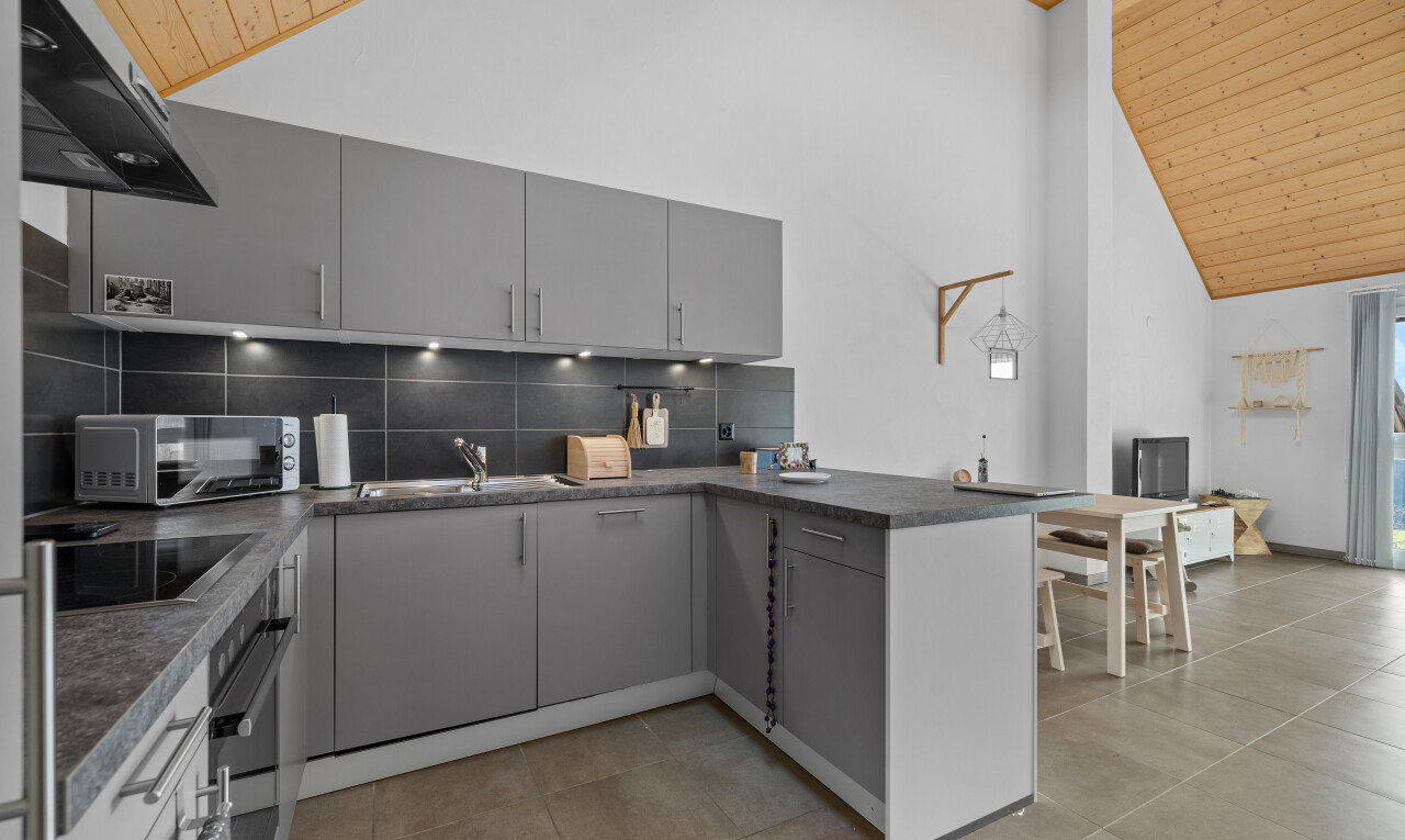 küche mit holzdecke, waschbecken, küchentheke, arbeitsplatten, und mikrowelle